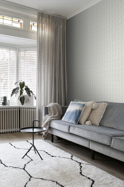 Wohnzimmer mit Sofa, Teppich und gemusterter Tapete