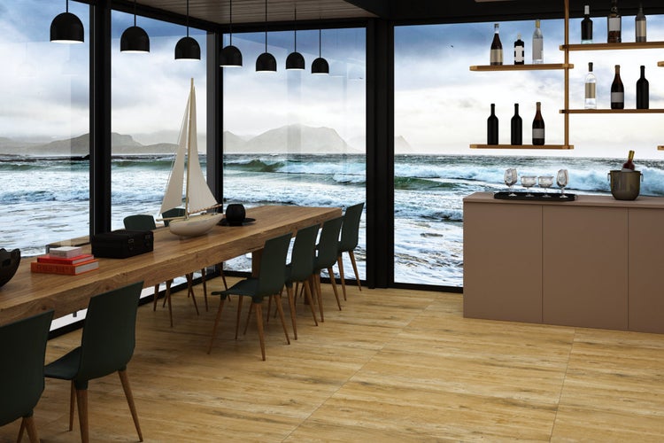 Heller Raum mit Holzboden, großem Holztisch, Stühlen und Meerblick durch Fenster