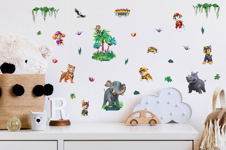 Paw Patrol Jungle Pups Wandsticker Set in einem Kinderzimmer mit verschiedenen Tieren und Dschungelmotiven über einer weißen Kommode.