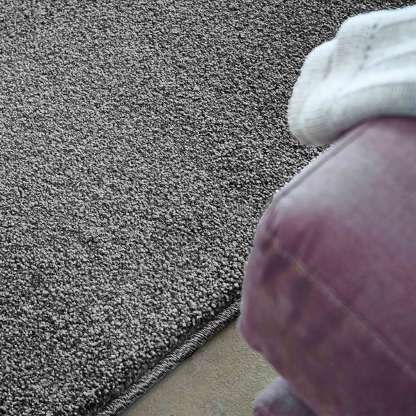 Hochflor-Teppich in Grau mit strukturierter Oberfläche neben einem Möbelstück.