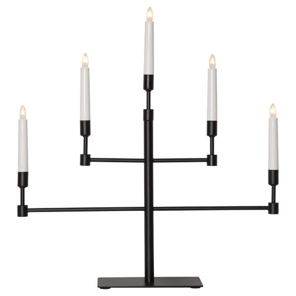 Dekorative Leuchte mit fünf Lichtern, Weihnachtskugeln und Grünpflanze auf einem Schrank