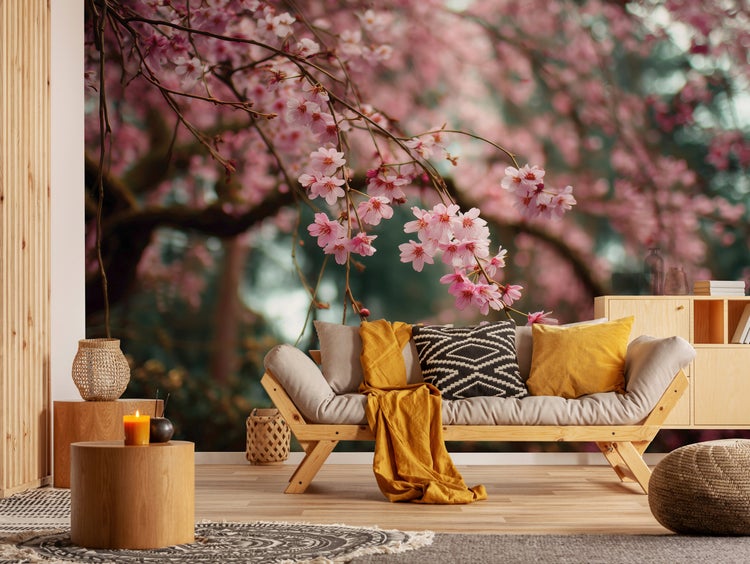 Vliestapete mit Kirschblütenmotiv in einem gemütlichen Wohnzimmer mit Holzmöbeln und weichen Textilien für eine naturnahe Wandgestaltung.