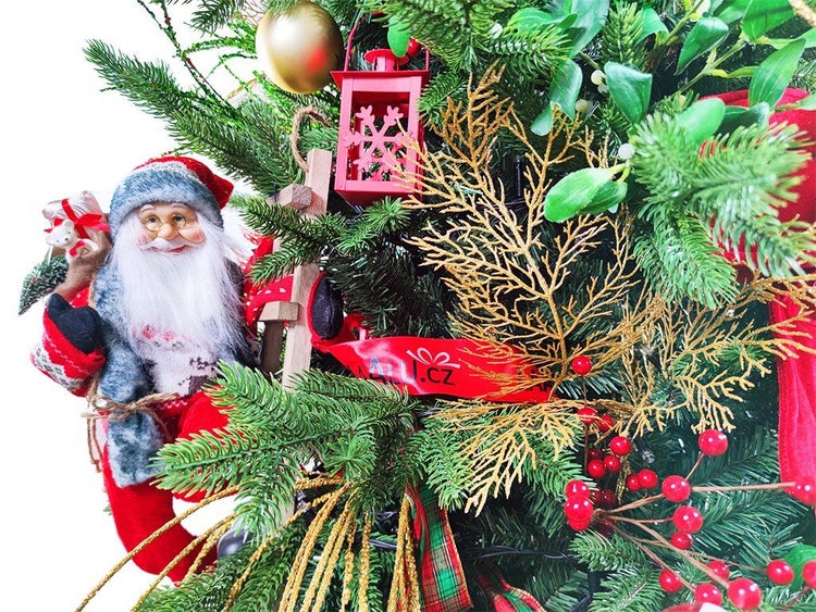 Weihnachtsbaumschmuck mit einer Weihnachtsmannfigur auf einer Leiter, Laterne, roten Beeren und Tannenzweigen.