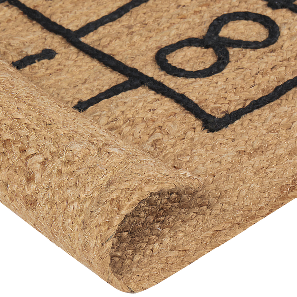 Detailansicht einer gewebten Fußmatte aus Jute mit schwarzem Muster und umgeschlagener Ecke.