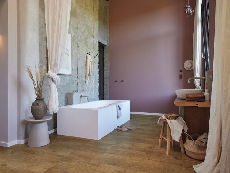 Modernes Badezimmer mit freistehender Badewanne, Aufsatzwaschbecken auf Holztisch und Holzoptik Bodenfliesen im rustikalen Stil.