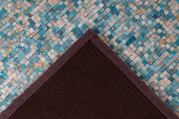 Gewebter Lederteppich aus blau-goldenen Patches mit dunkler Rückseite und eingefasstem Rand.