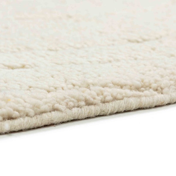 Nahaufnahme eines strukturierten Hochflor-Teppichs mit eingefasster Kante.