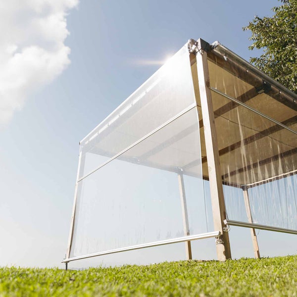 Transparente Senkrechtmarkise als Wind- und Wetterschutz an einer Holzpergola im Garten.