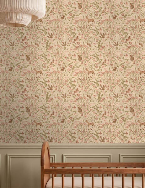 Vliestapete mit Naturmotiv aus Rehen, Hasen und Wiesenblumen im Kinderzimmer über einer Wandvertäfelung und einem Kinderbett aus Holz.