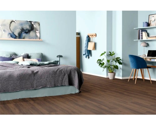 Schlafzimmer mit Bett, Schreibtisch, Pflanze und Holzboden