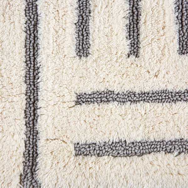 Detailansicht eines getufteten Teppichs mit Streifenmuster