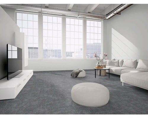Modernes, helles Wohnzimmer mit dunkelgrauem strukturiertem Teppichboden, großen Fenstern, weißem Sofa und weißen Möbeln im industriellen Loftstil.