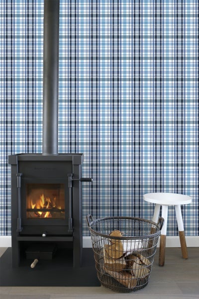 Wohnzimmer mit Kaminofen, Holzkorb und karierter Tapete