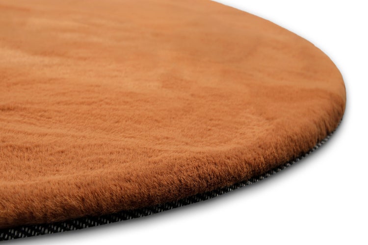 Runder, weicher Teppich in Braun mit flauschiger Oberfläche.