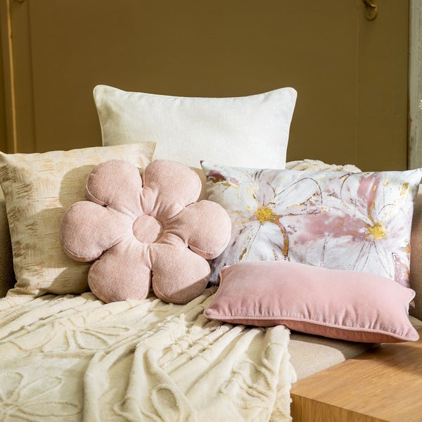 Dekorative Kissen und Kuscheldecke auf einem Sofa