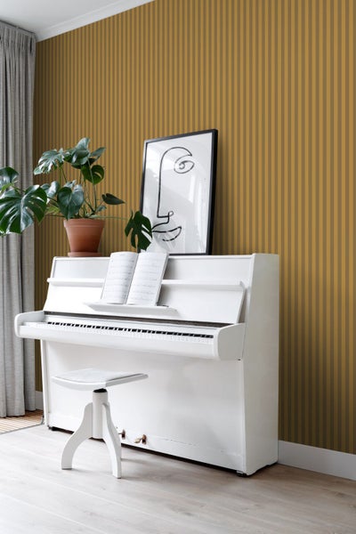 Zimmer mit gestreifter Tapete, weißem Klavier und Zimmerpflanze