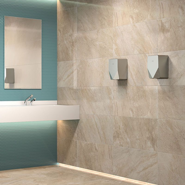 Moderner Händetrockner an einer Wand mit Natursteinfliesen in einem hellen Badezimmer mit Waschbecken und Spiegel.