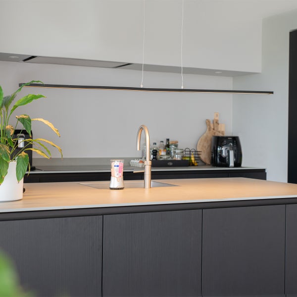 Moderne Küche mit Kücheninsel, Spüle, Armatur und linearer Pendelleuchte