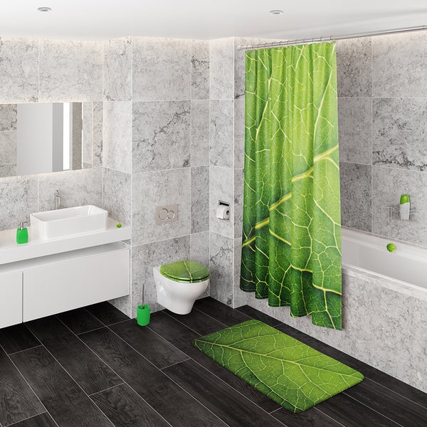 Modernes Badezimmer mit Duschvorhang, Toilettensitz und Badematte im Blatt Motiv Design, Fliesen in Steinoptik und weisse Badmöbel.