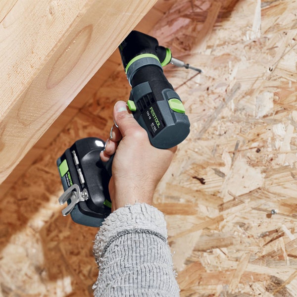 Eine Person schraubt eine Schraube mit einem Akku-Bohrschrauber in ein Holzbrett
