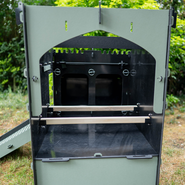 Innenansicht eines grünen Hühnerstalls mit zwei Sitzstangen aus Holz und pflegeleichten Kunststoffwänden.