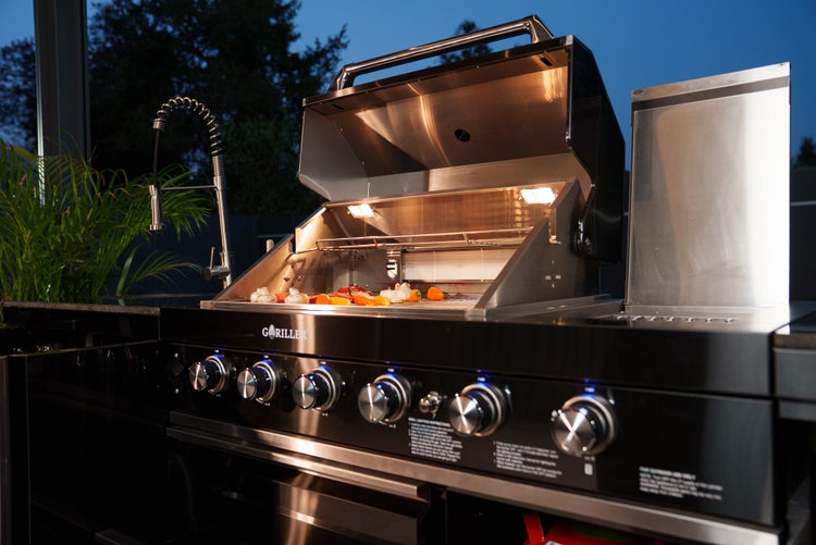 Moderner Gasgrill von GRILLER in einer Außenküche mit beleuchtetem Innenraum und beleuchteten Bedienknöpfen.