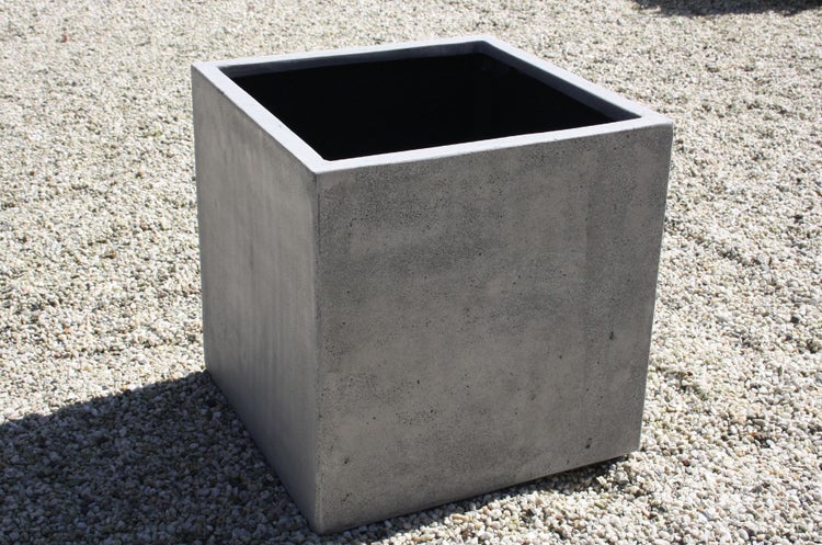Quadratischer Pflanzkübel aus grauem Beton, würfelförmiger Blumentopf für den Außenbereich.