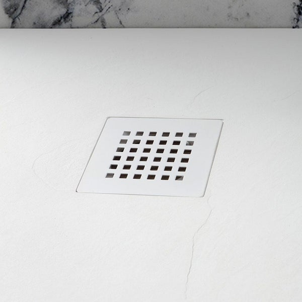 Quadratischer, weißer Duschabfluss mit Gitter in einer strukturierten Duschwanne.