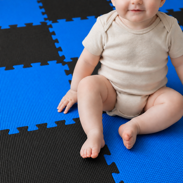 Ein Kleinkind sitzt auf einem Boden aus ineinandergreifenden Schaumstoffmatten als Puzzlematte.