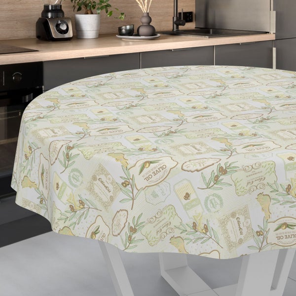 Runde Tischdecke mit Olivenöl-Motiven, Olivenzweigen und Etiketten auf einem Tisch in einer Küche.