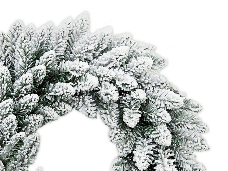 Künstlicher Adventskranz mit Kunstschnee auf den Nadelzweigen für die Weihnachtsdekoration