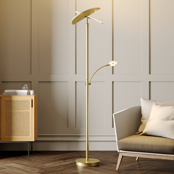 Goldfarbene Stehlampe mit verstellbarem Deckenfluter und flexiblem Lesearm in einem modern eingerichteten Wohnzimmer neben einem Sessel.
