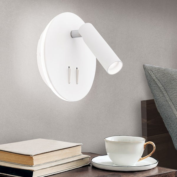 Wandleuchte mit USB-Anschluss über einem Nachttisch mit Büchern und einer Teetasse