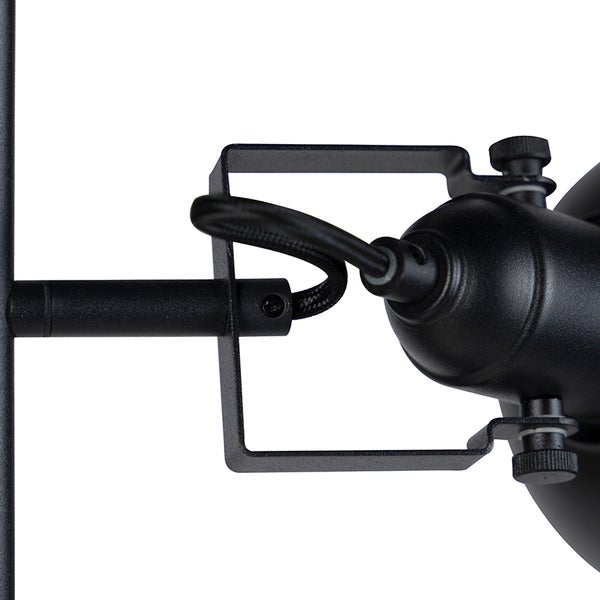 Detailaufnahme einer schwarzen Leuchte mit Kabel und Metallhalterung