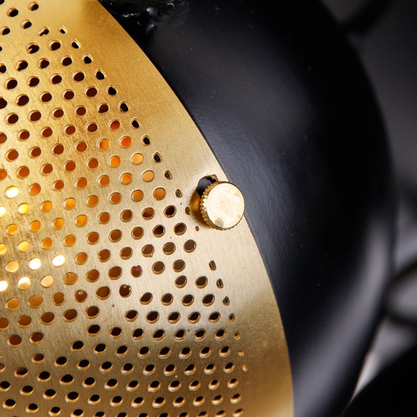 Detailansicht einer Lampe mit gelochtem Lampenschirm und Drehknopf