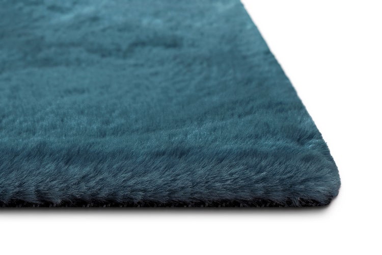 Hochflor-Teppich aus Kunstfell in Petrol, weiche Textur, Nahaufnahme einer Ecke.