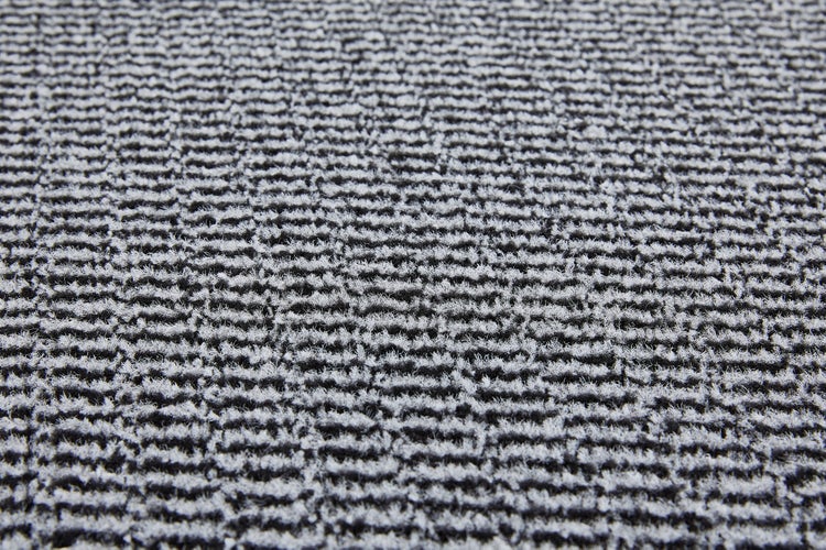 Nahaufnahme eines grauen Teppichs mit horizontalen Linien.