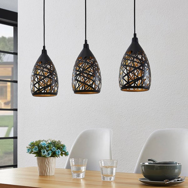 Dreiflammige Pendelleuchte aus schwarzem Metall mit gitterartigen Ausschnitten über einem hellen Esstisch.