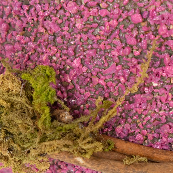 Dekoratives Gesteck mit pinkfarbenem Granulat und Moos