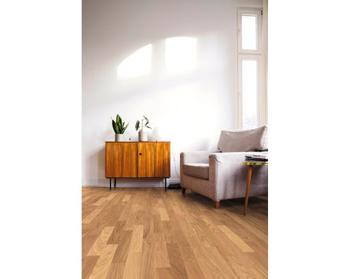 Wohnzimmer mit Holzboden, Sessel und Kommode