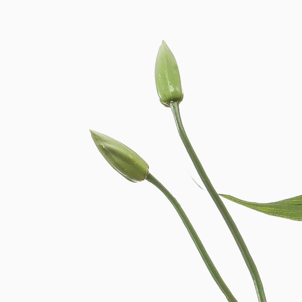 Künstliche Blauregen-Pflanze mit hängenden violetten Blütendolden und grünen Blättern an einem braunen Stamm.