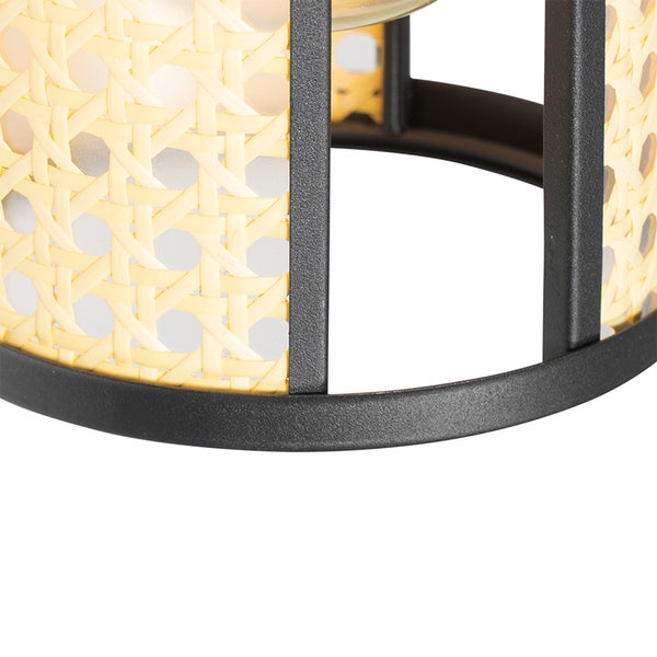 Detailansicht einer Lampe mit Rattan-Schirm und Metallelementen