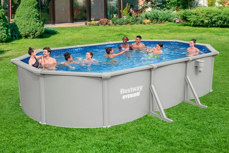 Ovaler Bestway Hydrium Stahlwandpool in Grau auf einer Wiese im Garten mit mehreren Personen im Wasser.