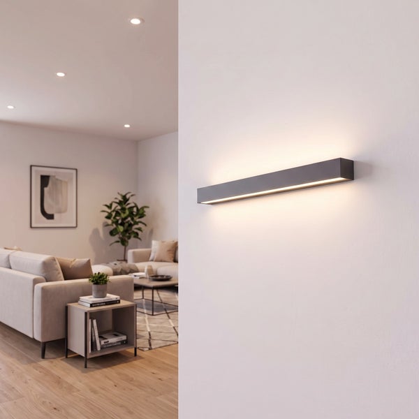Moderne rechteckige Wandleuchte mit indirekter LED Beleuchtung montiert an einer hellen Zimmerwand in einem modern eingerichteten Wohnbereich.