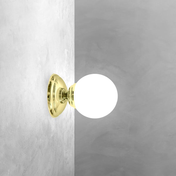 Wandleuchte mit rundem, weißem Glasschirm und goldfarbener Halterung