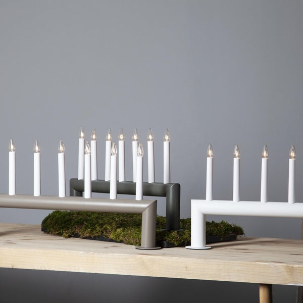 Drei elektrische Adventsleuchter aus Metall mit Kerzen auf einem Holztisch.