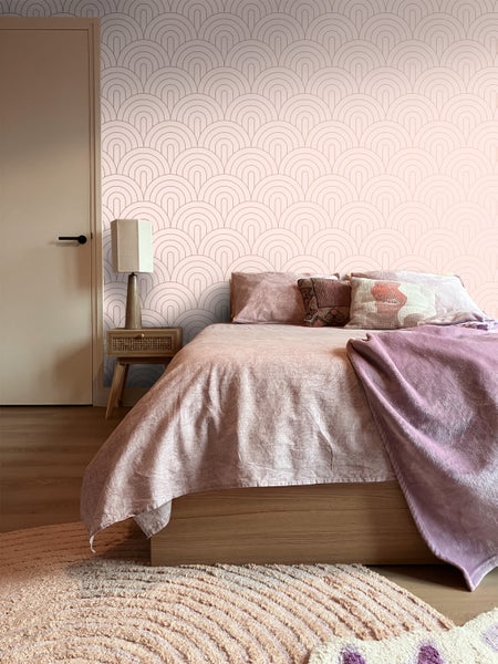 Schlafzimmer mit Bett, Nachttisch und Wandtapete im Art-Déco-Stil