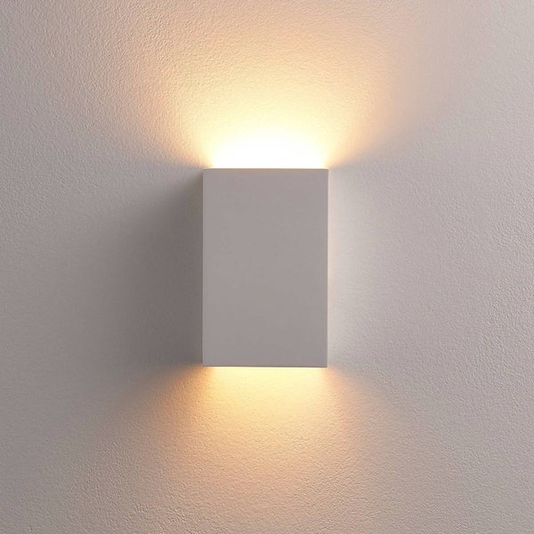 Rechteckige Wandleuchte mit Up-and-Down-Lichteffekt an einer strukturierten Wand.