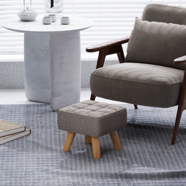 Szene mit Sessel, Fußhocker und Tisch mit Teegeschirr