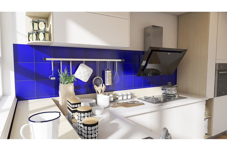 Küchenszene mit Spüle, Herd, Dunstabzugshaube, Geschirr und Kochutensilien vor blau gefliester Wand